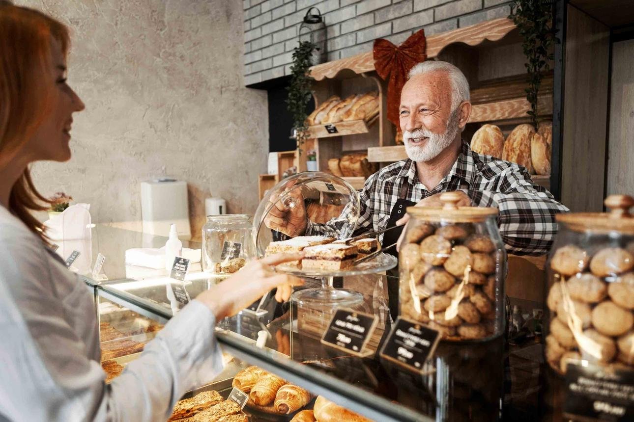 A local baker welcoming a customer over the counter